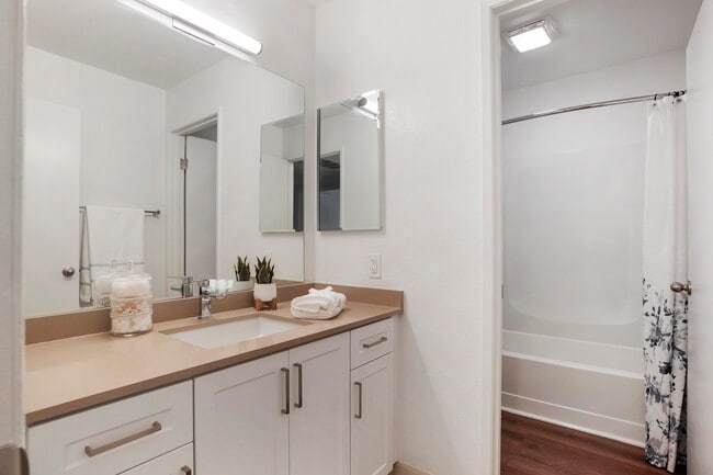 Baths with beige quartz countertops and white cabinetry