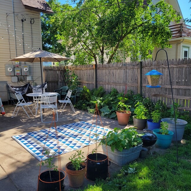 Patio trasero con valla de privacidad y patio de cemento. - 783 Edmund Ave W