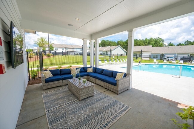 Covered patio on the pool deck with lounge seating.