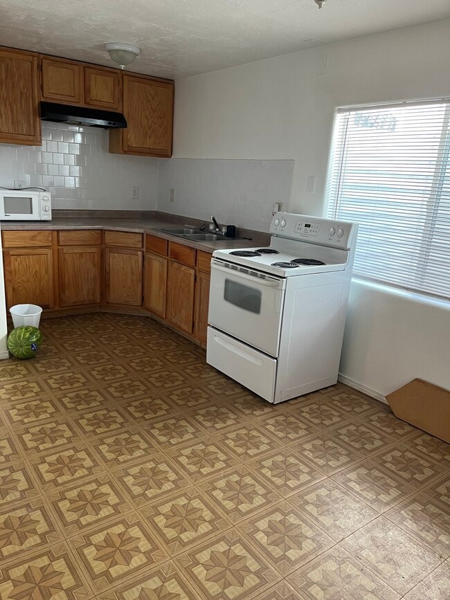 Kitchen with a fridge and the dining area. - 3139 S Marseilles Way Unit Rose Apartment
