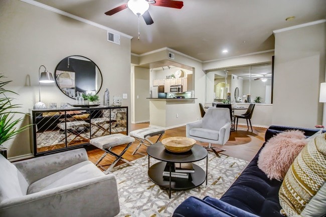 Gorgeous living room with hardwood style flooring, crown molding and ceiling fan - Colonnade at Willow Bend