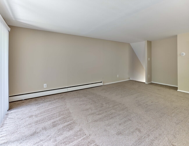 Spacious living room with plush carpet and open layout at Maple Terrace Apartments in Maple Shade, NJ