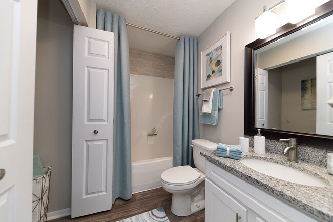 Bright bathroom with granite counters and bathtub