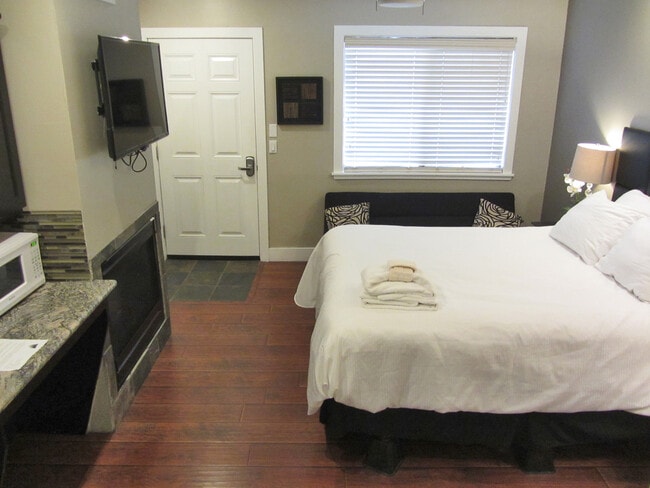 Bed and living area - 4069 Cedar Ave Unit Studio for assist. Manage