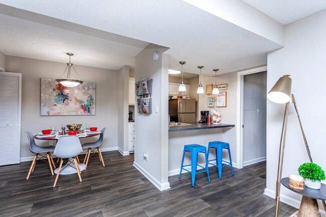 Open-concept dining space with breakfast bar and modern flooring.