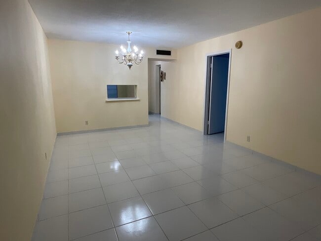 Looking from living room area toward dining room with a pass through to kitchen - 2900 NW 47th Terrace Unit 103