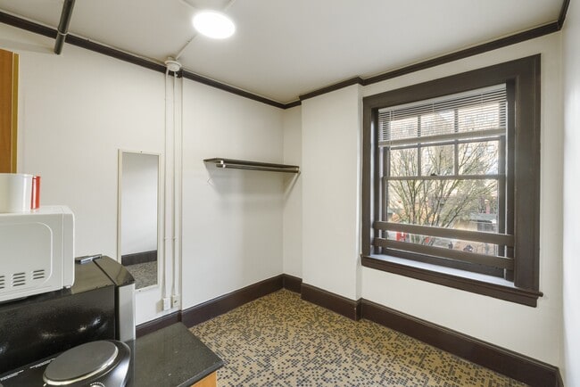 Studio living space with cooking area, refrigerator, microwave