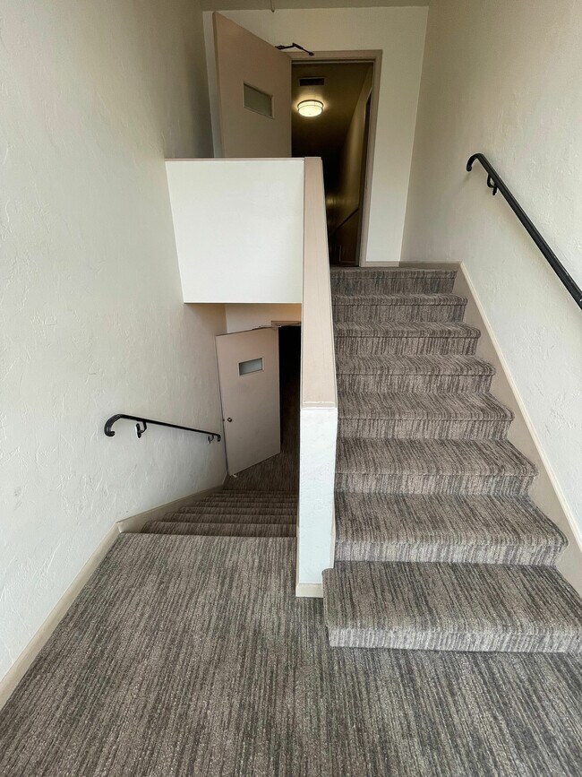 Explore el elegante diseño de la escalera de este apartamento, que ofrece acceso perfecto a los niveles superiores.