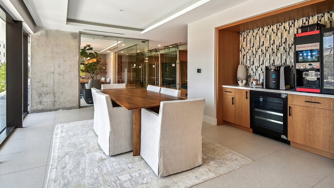 Griffis West Palm apartment coworking lounge with coffee machine and dining table. - Griffis West Palm