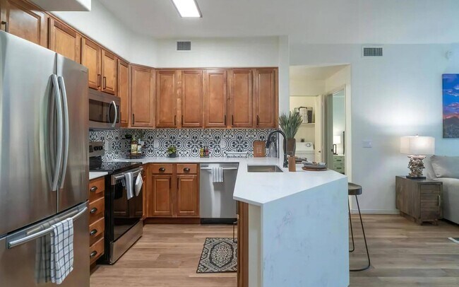 Open Kitchen with Island Seating and Wood Cabinetry - Desert Parks Vista