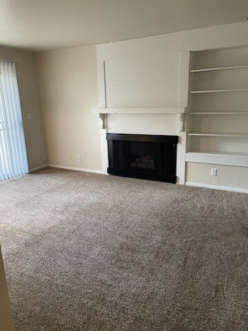 Living room w/ fireplace- carpet flooring