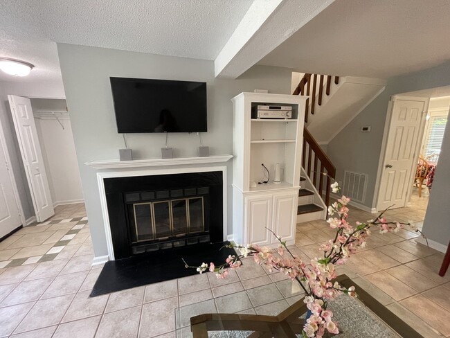 Sala de estar con centro de entretenimiento empotrado, soporte telescópico para TV y sistema de sonido envolvente con cable. - 4204 Whistler Ct