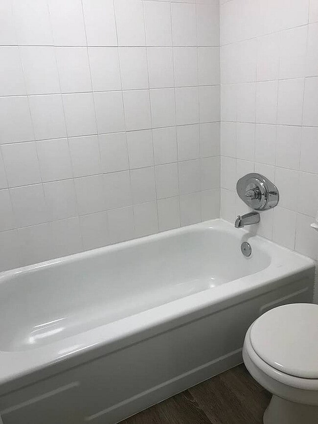 Elegante baño con una bañera blanca impecable, elegantes paredes de azulejos y accesorios cromados modernos que ofrecen un refugio refrescante.