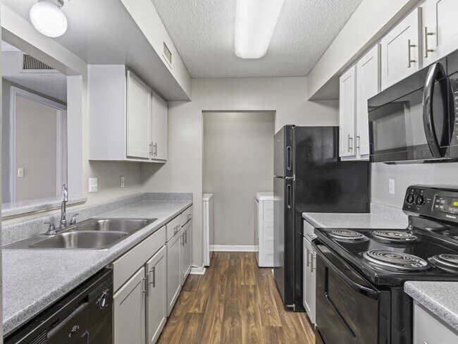 Cook in style with kitchens featuring bright white cabinetry and sleek black appliances, professionally operated by Highlands Vista Group.