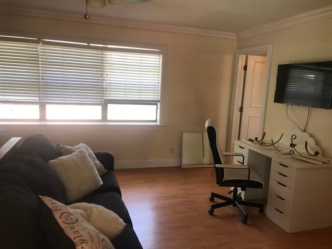 desk, chair TV on wall couchntrance to bathroom - 630 NW 7th Ave Unit 3