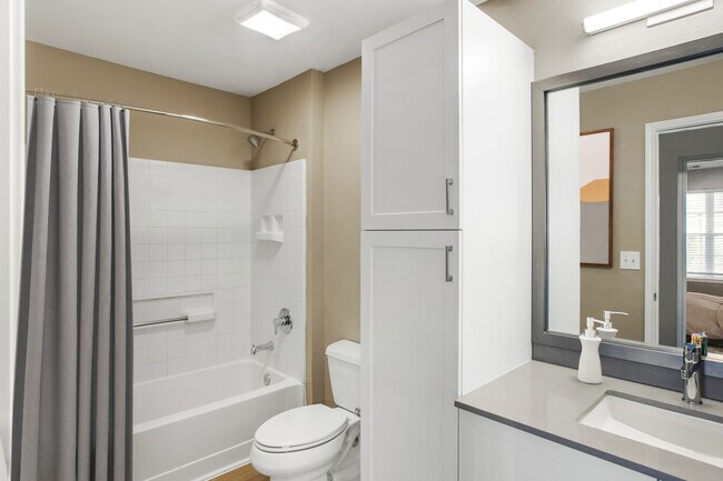 Upgrade Scheme II bath with white shaker cabinetry, grey quartz countertops, and hard surface flooring