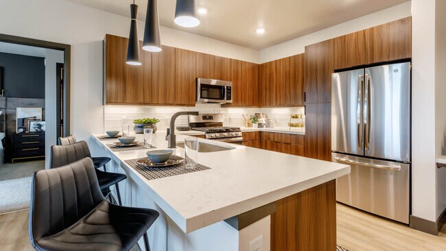 Cocina con barra de desayuno y electrodomésticos de acero inoxidable. - Circa Fitzsimons