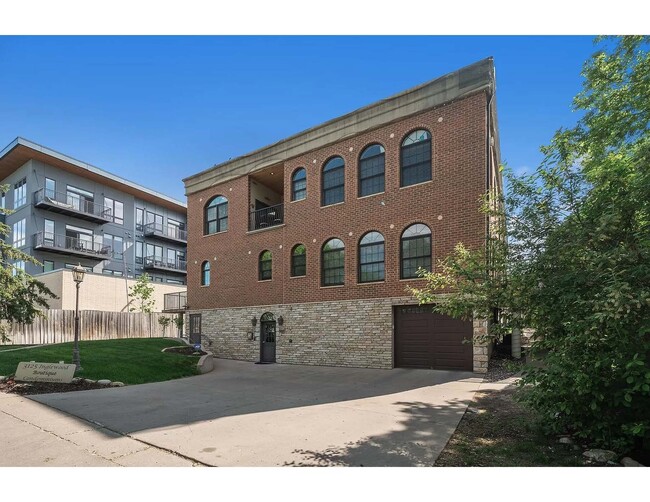 Exterior of building. West facing, garage door to indoor parking garage. West-facing balcony - 3125 Inglewood Ave S Condo Unit 201