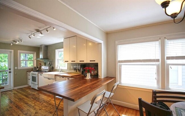 The kitchen has been lovingly updated with Maple countertops, a Breakfast Bar with seating for 4, a white Farm Sink, subway tile backsplash AND soft-close IKEA Cabinets - 903 Highland Rd House