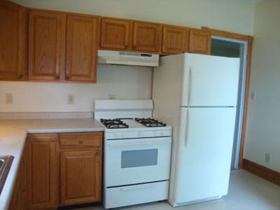 Kitchen with gas stove and refrigerator. Sink is to left. - 512 S Center St Unit Fl. 1