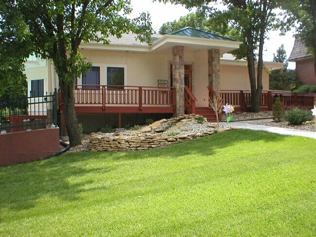 A welcoming clubhouse surrounded by lush green grass at Cedar Ridge Apartments.