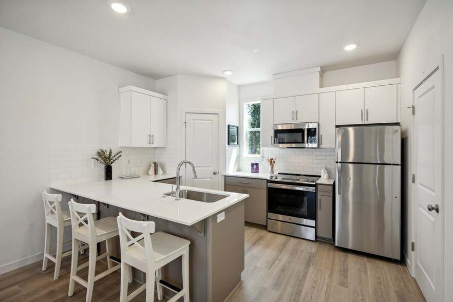Tile backsplash, quartz counters, and abundant storage.