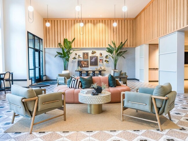Experience the welcoming ambiance of the Modera Woodstock leasing office, featuring stylish seating and curated artwork that reflect the community’s modern Portland charm. - Modera Woodstock