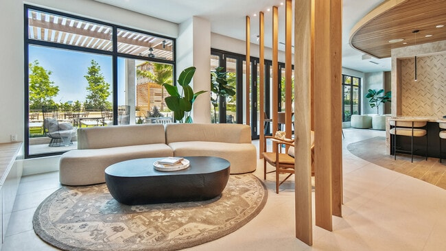 Griffis West Palm apartments resident lounge with plush couch, coffee table with books, and elegant decor. - Griffis West Palm