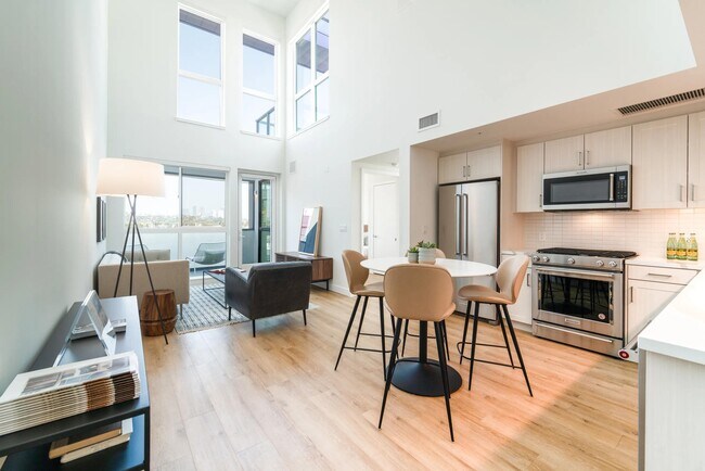 Loft-style home with soaring ceilings, oversized windows, and an open kitchen that fills the space with natural light and expansive views.