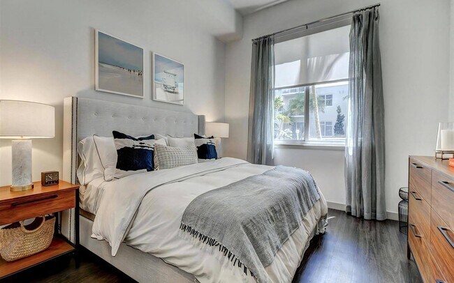 Wood-tone flooring covers the bedroom too, with a wide window for light.