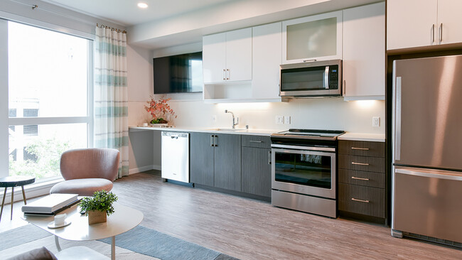 Stunning Galley-style kitchens with stainless steel appliances and wood plank flooring - Modera San Pedro Square Apartments