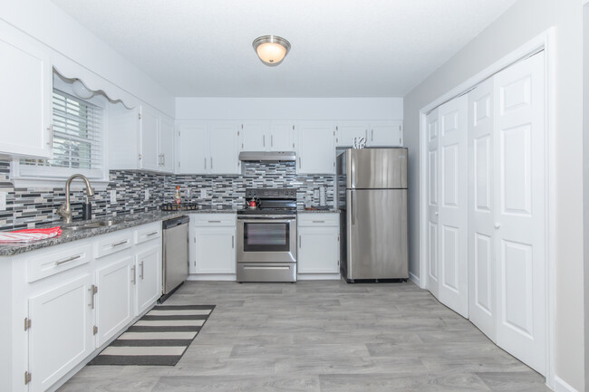 White shaker cabinetry, stone countertops, plank flooring - Elements44 Apartments