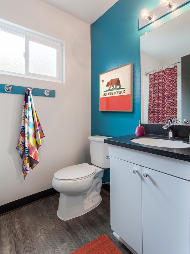 Classic Package III bath with black quartz countertops, white cabinetry, and hard surface flooring
