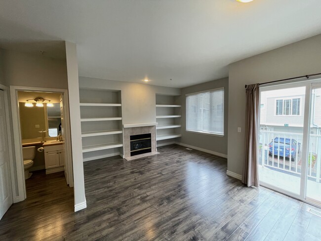 living room with gas fireplace and built-in shelving - 13400 Dumas Rd Townhome