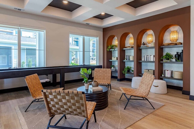 Relax in our stylish clubhouse nook, where curated arched shelving and woven seating create a warm, design-forward gathering space. Or if you're looking for a little more excitement, enjoy our shuffleboard table with friends. - Garrett Gateway