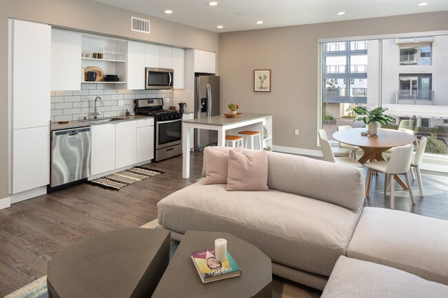 Open concept kitchen and living area with hard surface flooring - AVA Hollywood at La Pietra Place