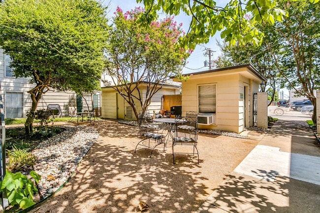 Common interior courtyard with tables and outdoor grill. Laundry room on right. - 4901 Bryce Ave Unit 10