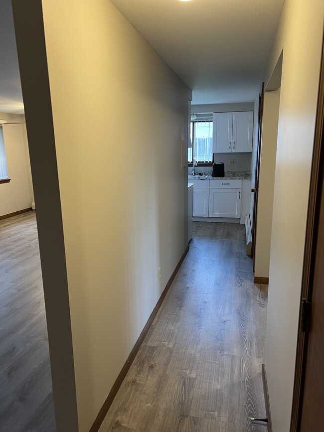 Hallway into the condo leading into the kitchen. New flooring throughout. - 3890 Ridge Lea Rd Condo Unit Crystal Commons