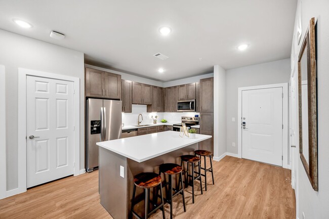 Experimente la combinación perfecta de estilo y funcionalidad en esta cocina moderna. Con elegantes gabinetes de madera oscura, una amplia isla con encimera de cuarzo y electrodomésticos de acero inoxidable, este espacio está diseñado para impresionar. Disfrute de la comodidad de un amplio espacio de almacenamiento, un microondas incorporado y un... - The Delta Pearland Apartamentos