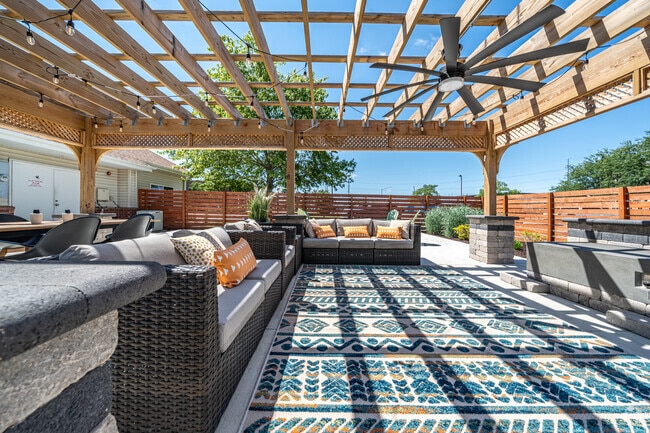 Espacio de salón al aire libre con pérgola y fogatas
