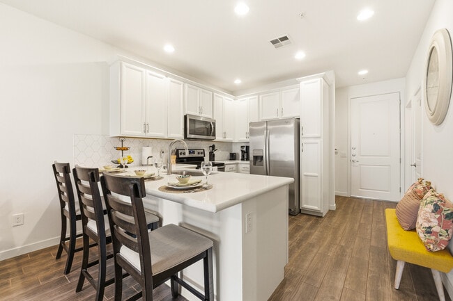 Modern, fully equipped kitchen with quartz countertops and stainless-steel appliances. - 2511 W Queen Creek Rd Unit 324