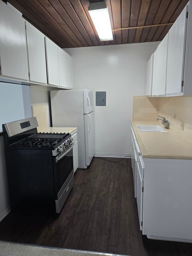 Kitchen. new paint,Tiled counter, refrigerator, vinyl plank flooring