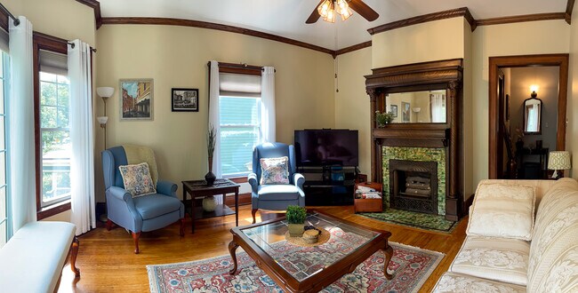 [Living Room] Spacious room with large windows, provides a beautiful view of a tree-lined street. - 103 Lancaster Ave Unit 3