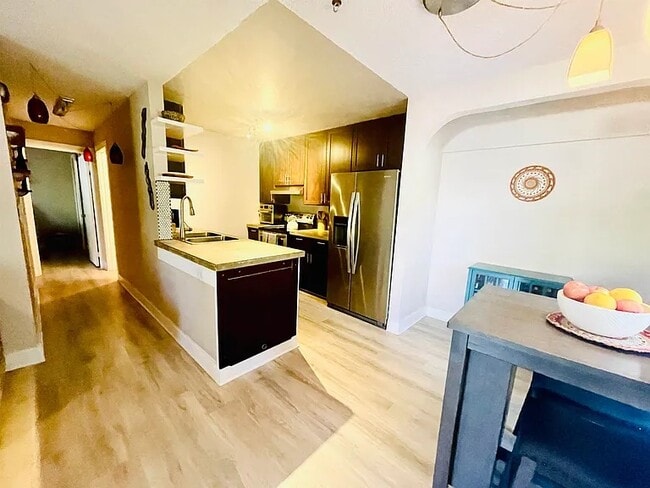 Open concept kitchen with polished concrete counter-tops and modern splashback - 140 Uwapo Rd Unit 53-101