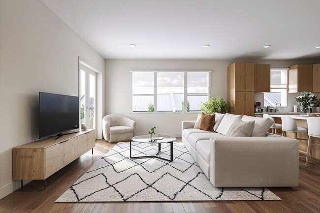 Bright living room with large windows, modern furniture, and natural light.