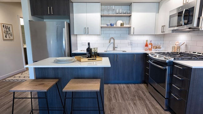 Las cocinas tienen acabados lujosos que incluyen electrodomésticos de acero inoxidable y encimeras de cuarzo - Modera South Lake Union Apartamentos