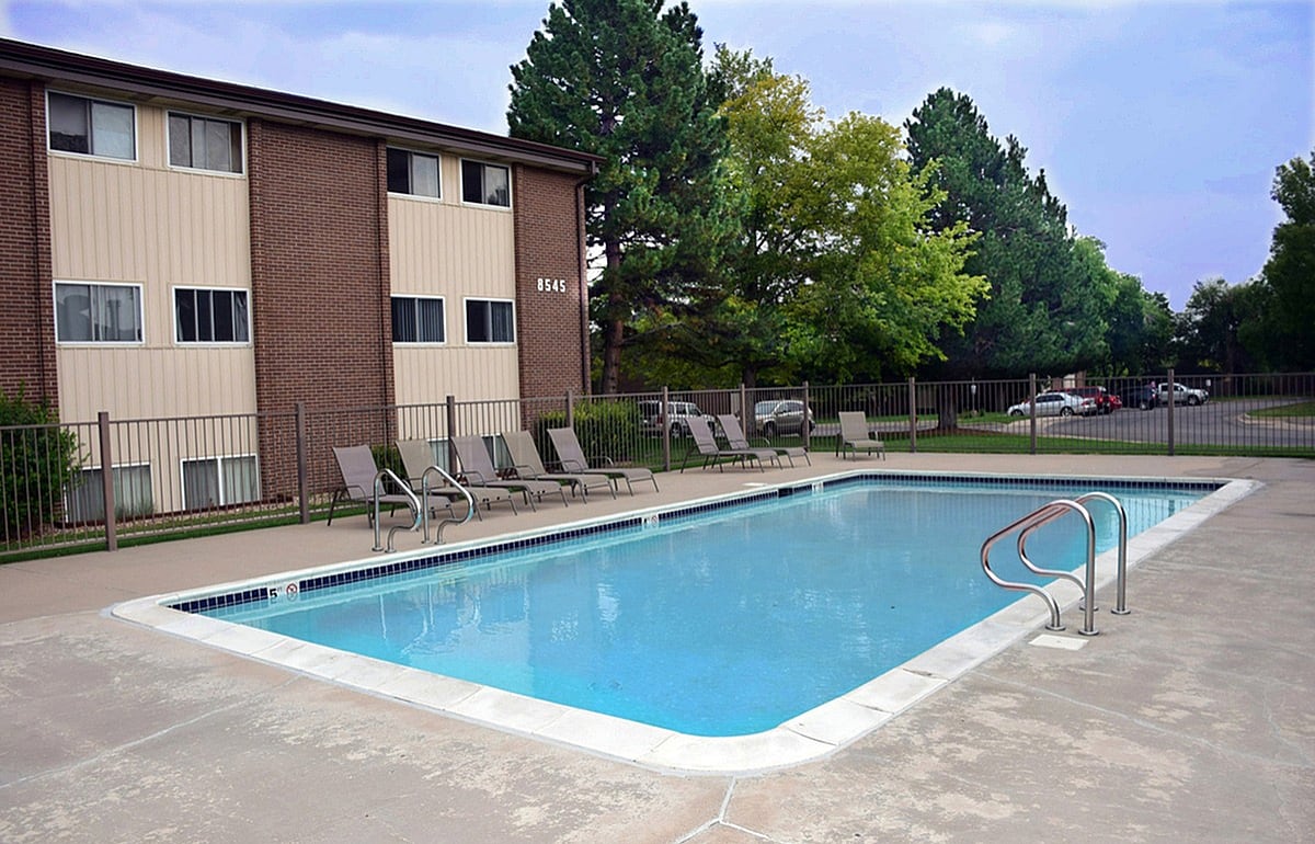Relax by the sparkling pool in our residential community, perfect for leisure and enjoyment. - PINETREE Apts