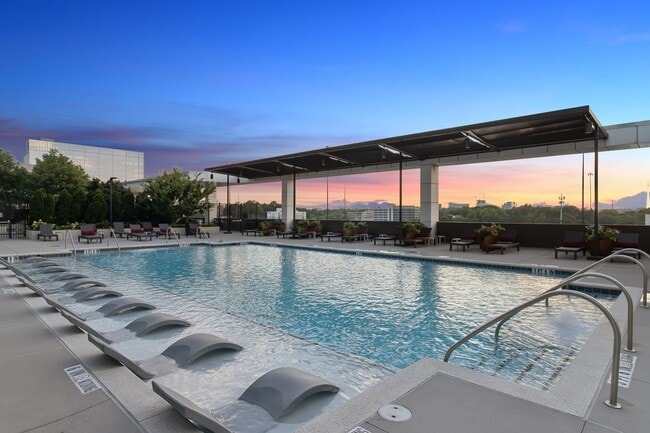 Resort-style pool with lounge seating and sun shade