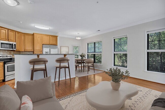 A modern kitchen with wooden cabinets and a dining area with a table and chairs.