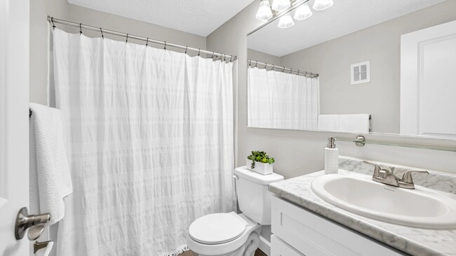 Step into elegant bathrooms featuring wood-style floors and marble-style countertops.